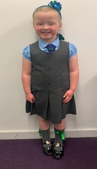Girl wears blue shirt with the school ties and grey dress on top