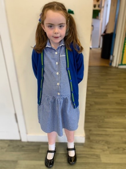 Girl wears blue check dress with blue cardigan over the top